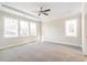 Spacious bedroom with neutral carpet, tray ceiling, and large windows at 148 Palm St, Holly Springs, GA 30115