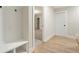 Welcoming mud room features bright white paint, wood floors, built in bench and coat hooks at 148 Palm St, Holly Springs, GA 30115