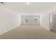 A large bonus room with neutral carpet is filled with natural light from two sun-lit windows at 1628 Palladian Dr, Lithonia, GA 30058