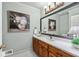 Bathroom featuring wood cabinets, white marble countertop, large mirror, and decorative wall art at 2065 Innsfail Dr, Snellville, GA 30078
