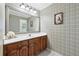A bathroom featuring wood cabinets, a sink, and wallpaper at 2065 Innsfail Dr, Snellville, GA 30078