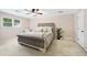 Comfortable bedroom boasts neutral decor, a tufted headboard, and a bright window at 2065 Innsfail Dr, Snellville, GA 30078