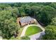A beautiful brick home surrounded by lush greenery, featuring a circular driveway and well-maintained landscaping at 2065 Innsfail Dr, Snellville, GA 30078