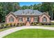 Charming single-story brick home featuring a lush lawn, circular driveway, and manicured landscaping at 2065 Innsfail Dr, Snellville, GA 30078