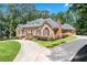Elegant single-story brick home with circular drive, lush landscaping, and attached garage at 2065 Innsfail Dr, Snellville, GA 30078