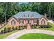 Charming brick home with manicured landscaping and a circular driveway at 2065 Innsfail Dr, Snellville, GA 30078