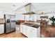 Open-concept kitchen with island cooktop, stainless steel appliances, and hardwood flooring; adjacent to the dining area at 2065 Innsfail Dr, Snellville, GA 30078