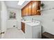 Well-lit laundry room with a washer, dryer, storage cabinets, and tiled flooring at 2065 Innsfail Dr, Snellville, GA 30078