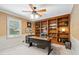 Office space featuring built-in bookshelves, neutral wall-to-wall carpeting, and a modern desk at 2065 Innsfail Dr, Snellville, GA 30078