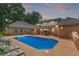 A serene backyard pool area with comfortable lounge chairs and lush landscaping, ideal for outdoor enjoyment at 2065 Innsfail Dr, Snellville, GA 30078