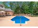 Large backyard pool surrounded by lush greenery and lounge chairs, perfect for relaxation and outdoor entertainment at 2065 Innsfail Dr, Snellville, GA 30078