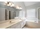 Well-lit bathroom with double vanity, soaking tub, and separate shower at 655 Golden Meadows Ln, Suwanee, GA 30024