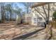 Back exterior of home featuring a deck with stairs, a patio, and surrounded by mature trees at 115 Flagstop Run, Fayetteville, GA 30215