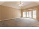 Spacious bedroom with carpet flooring, a ceiling fan, and french doors leading to the backyard at 115 Flagstop Run, Fayetteville, GA 30215