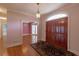 Inviting entryway with hardwood floors, chandelier, and double doors to the beautiful interior of the house at 115 Flagstop Run, Fayetteville, GA 30215