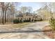 Stately home showcasing a long driveway, manicured lawn, mature trees, and charming fountain, creating a welcoming curb appeal at 115 Flagstop Run, Fayetteville, GA 30215