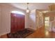 Elegant foyer with hardwood floors, double front doors, decorative chandelier, and staircase leading to the upper level at 115 Flagstop Run, Fayetteville, GA 30215