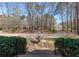 Expansive front yard view featuring a tiered fountain and winding driveway, surrounded by lush landscaping and mature trees at 115 Flagstop Run, Fayetteville, GA 30215