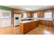 Kitchen with central island, oak cabinetry, white appliances, and eat-in area at 115 Flagstop Run, Fayetteville, GA 30215
