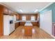 Functional kitchen with wood cabinets, central island, and double closet at 115 Flagstop Run, Fayetteville, GA 30215