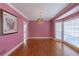 Living room with hardwood floors, picture window, chandelier and pink walls at 115 Flagstop Run, Fayetteville, GA 30215