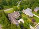 An aerial view shows a house with mature trees, a large drive way, and manicured lawn at 2403 Wistful Way, Marietta, GA 30066