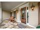 Inviting front porch featuring stone flooring, sconce lighting and a stained wood front door with glass panes at 2403 Wistful Way, Marietta, GA 30066