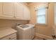 Functional laundry room with storage cabinets, modern appliances, and natural light for added convenience at 2403 Wistful Way, Marietta, GA 30066