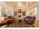 Open-concept living room with high ceilings, fireplace, built-in shelves, and comfortable leather seating at 2403 Wistful Way, Marietta, GA 30066