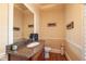 Stylish powder room with granite countertop, decorative mirror, and hardwood floors at 2403 Wistful Way, Marietta, GA 30066