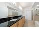 Bathroom featuring double sinks, black countertops, and a glass shower at 390 17Th Nw St # 2053, Atlanta, GA 30363
