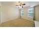 Bright bedroom features neutral carpet, ceiling fan, and natural light from two windows at 390 17Th Nw St # 2053, Atlanta, GA 30363