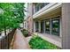 Exterior side view shows the entry with brick and green bushes at 390 17Th Nw St # 2053, Atlanta, GA 30363