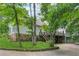 Back exterior of home featuring a deck, patio, and lush greenery with mature trees at 34 Johnston Nw Row, Cartersville, GA 30121