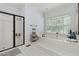 Primary bathroom with a walk-in shower, soaking tub under a window, and neutral accents at 34 Johnston Nw Row, Cartersville, GA 30121