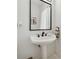 Bathroom featuring a pedestal sink with dark fixture, framed mirror, and neutral paint at 34 Johnston Nw Row, Cartersville, GA 30121