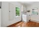 Bright laundry area with white appliances, window, and hardwood flooring near rear door at 34 Johnston Nw Row, Cartersville, GA 30121