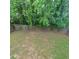 Large fenced backyard with grass and mature trees provides privacy and space at 3045 Binghampton Ln, Lawrenceville, GA 30044