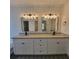 Dual sink bathroom with granite countertops, white cabinetry, and modern lighting at 3045 Binghampton Ln, Lawrenceville, GA 30044