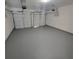 Spacious garage with two white garage doors and a sealed gray concrete floor at 3045 Binghampton Ln, Lawrenceville, GA 30044