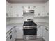 Well-equipped kitchen with stainless steel range, white cabinets, modern backsplash and granite countertops, designed for culinary enthusiasts at 3045 Binghampton Ln, Lawrenceville, GA 30044