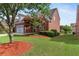 View of the house, surrounded by lush greenery, red brick, and a well-maintained lawn at 1979 Spivey Village Dr, Jonesboro, GA 30236