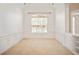 Empty carpeted room with wainscoting and a large window, offering a blank canvas for customization at 1979 Spivey Village Dr, Jonesboro, GA 30236