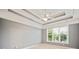 Main bedroom features a tray ceiling with fan, neutral carpeting, and large windows for natural light at 1979 Spivey Village Dr, Jonesboro, GA 30236