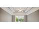 Bedroom features a tray ceiling with fan, neutral colored walls, and a large window for natural light at 1979 Spivey Village Dr, Jonesboro, GA 30236