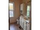 Bathroom with white cabinets, sink, toilet, and window at 7472 Woods Ct, Lithonia, GA 30058