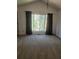 Spacious bedroom featuring neutral carpet, large windows, and vaulted ceiling with dark patterned curtains at 7472 Woods Ct, Lithonia, GA 30058