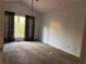 Spacious bedroom featuring neutral carpet, large windows, and vaulted ceiling with dark patterned curtains at 7472 Woods Ct, Lithonia, GA 30058