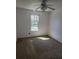 Bedroom featuring neutral carpet, a ceiling fan, and a window allowing natural light at 7472 Woods Ct, Lithonia, GA 30058