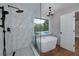 Bathroom featuring a standalone tub, glass shower, and views of the backyard pool at 858 Pates Creek Rd, Stockbridge, GA 30281